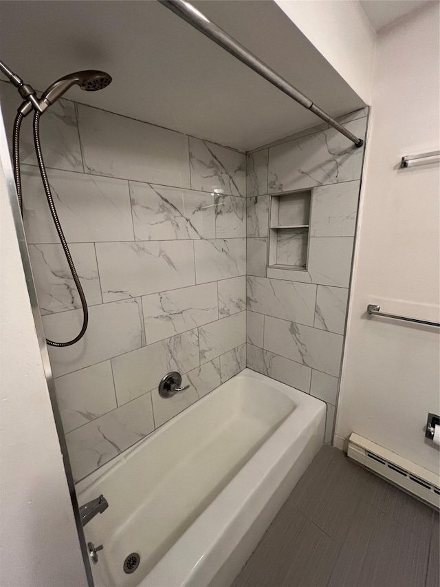 bathroom with tiled shower / bath and a baseboard heating unit