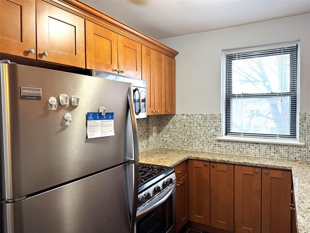 143-50 Hoover Ave Unit 204, Briarwood, NY 11435 - kitchen featuring brown cabinets, backsplash, appliances with stainless steel finishes, and light stone countertops
