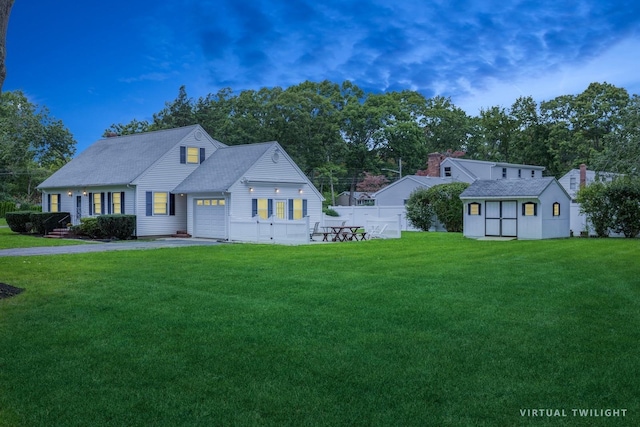 view of front of house with an outbuilding, a garage, fence, driveway, and a front yard