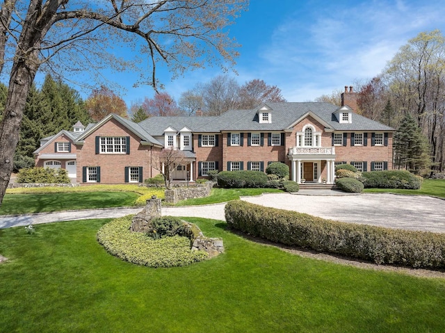 182 Taconic Rd, Greenwich, CT 06831 - georgian-style home featuring brick siding, a front yard, a chimney, and curved driveway