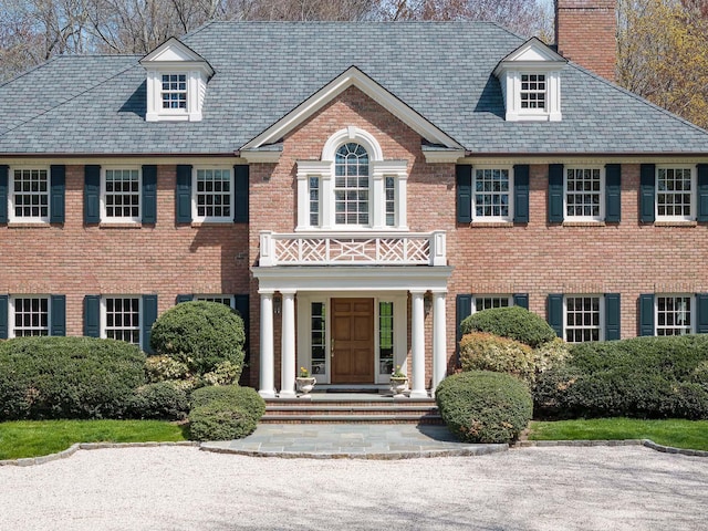 182 Taconic Rd, Greenwich, CT 06831 - colonial home featuring a high end roof, a balcony, a chimney, covered porch, and brick siding