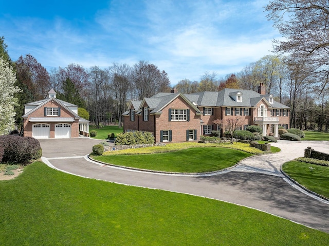 182 Taconic Rd, Greenwich, CT 06831 - view of front of house with aphalt driveway, a front lawn, a chimney, and brick siding