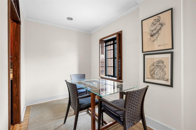 dining room with ornamental molding and light wood-type flooring