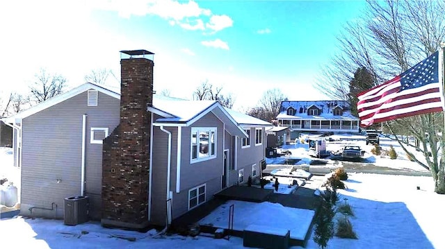 view of snowy exterior featuring cooling unit