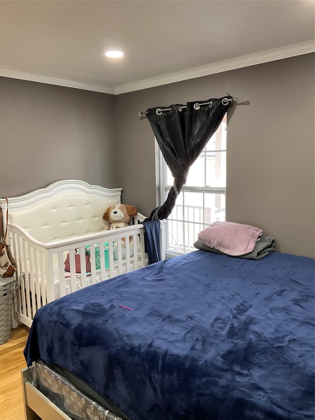 bedroom with hardwood / wood-style flooring and ornamental molding