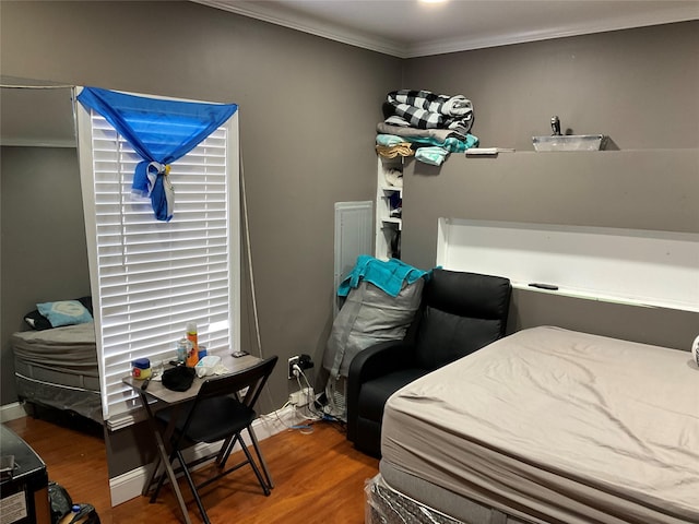 bedroom with hardwood / wood-style flooring and crown molding