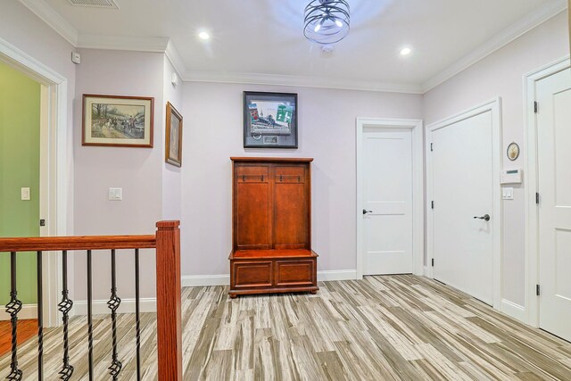 hall featuring crown molding and light hardwood / wood-style floors