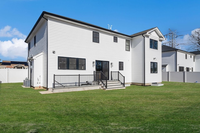 back of property featuring a lawn and central air condition unit