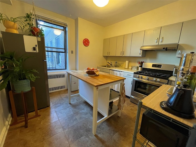 kitchen featuring radiator, wood counters, stainless steel gas stove, dishwasher, and sink