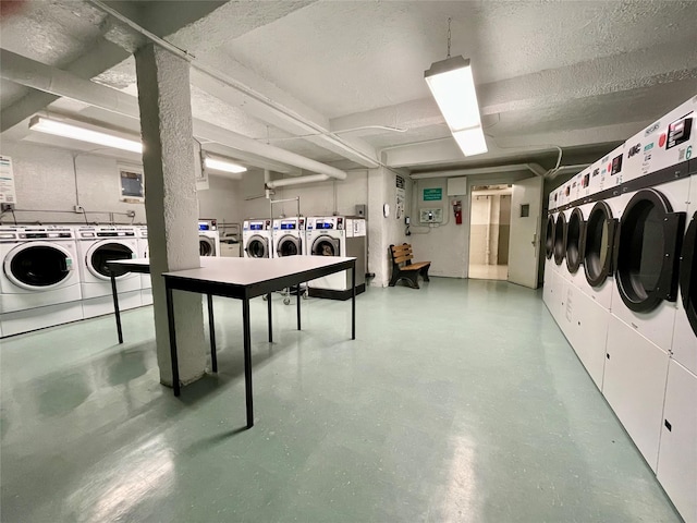 clothes washing area with separate washer and dryer and a textured ceiling