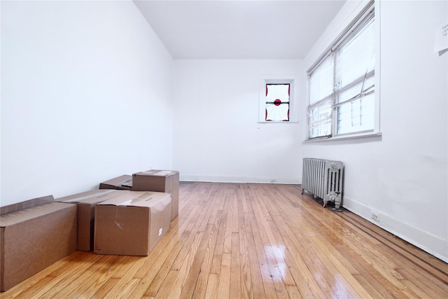 empty room with radiator heating unit and light hardwood / wood-style floors