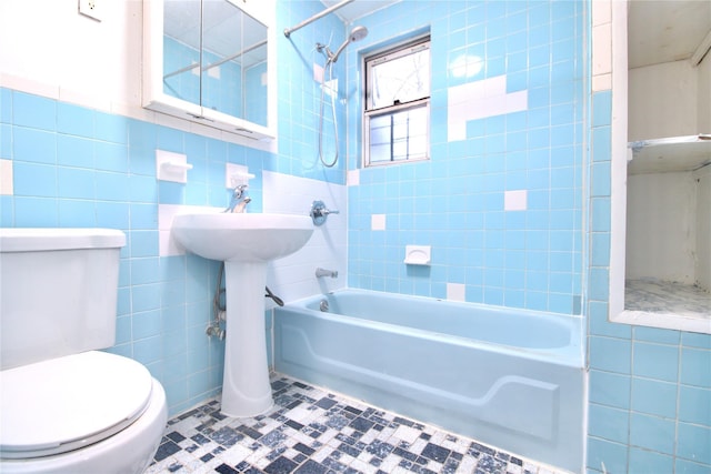 bathroom featuring toilet, tiled shower / bath combo, and tile walls