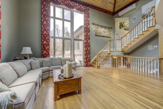 living room with hardwood / wood-style floors, a towering ceiling, and plenty of natural light