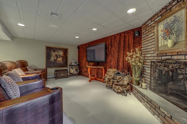 carpeted living room with baseboard heating, wooden walls, and a brick fireplace