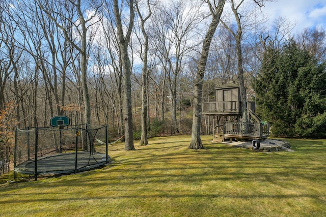 view of yard featuring a wooden deck and a trampoline