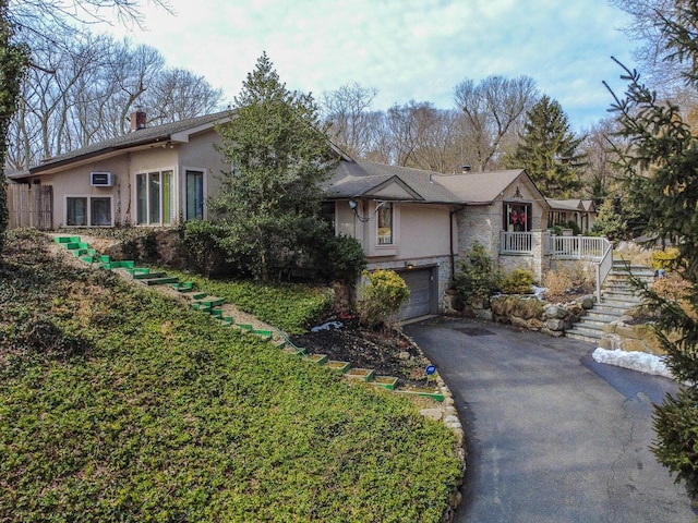 121 Laurel Ln, Laurel Hollow, NY 11791 - view of front of house featuring stone siding, stucco siding, asphalt driveway, and a garage