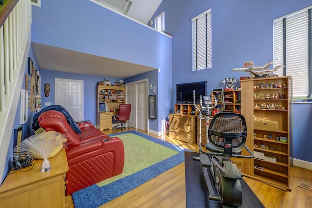 121 Laurel Ln, Laurel Hollow, NY 11791 - living room with a desk, wood finished floors, a towering ceiling, and baseboards