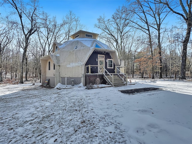 view of snow covered back of property