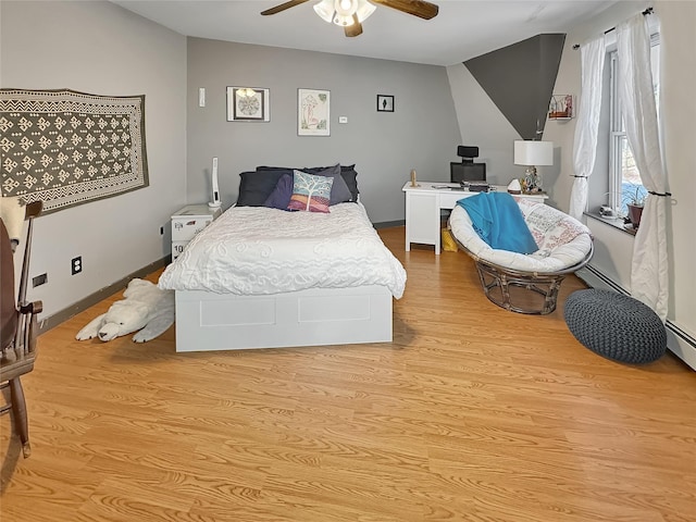 bedroom featuring a baseboard radiator, ceiling fan, and light hardwood / wood-style flooring