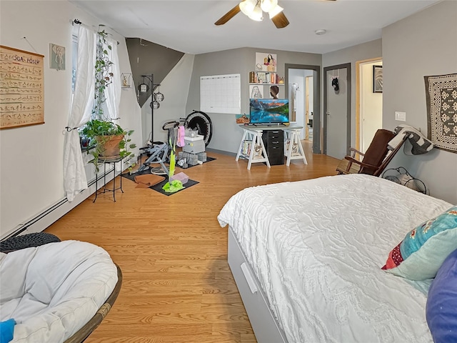 bedroom with baseboard heating, ceiling fan, and light hardwood / wood-style floors