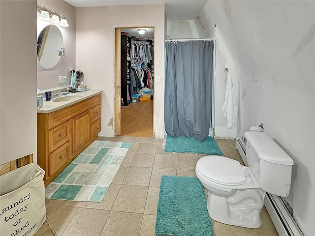 bathroom with baseboard heating, tile patterned floors, vanity, and toilet