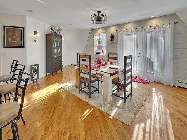 dining space with baseboard heating and light wood-type flooring