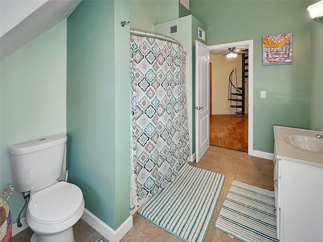 bathroom with ceiling fan, vanity, curtained shower, tile patterned floors, and toilet