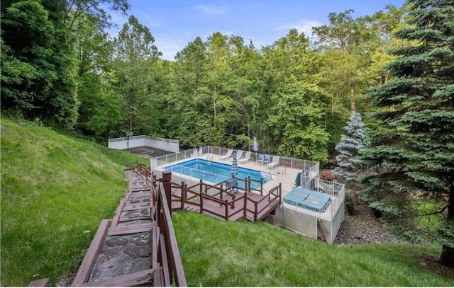 view of swimming pool featuring a yard