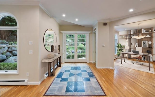 entryway featuring baseboard heating, crown molding, and light wood-type flooring