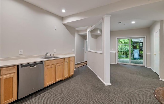 kitchen featuring sink, stainless steel dishwasher, light brown cabinetry, and dark carpet