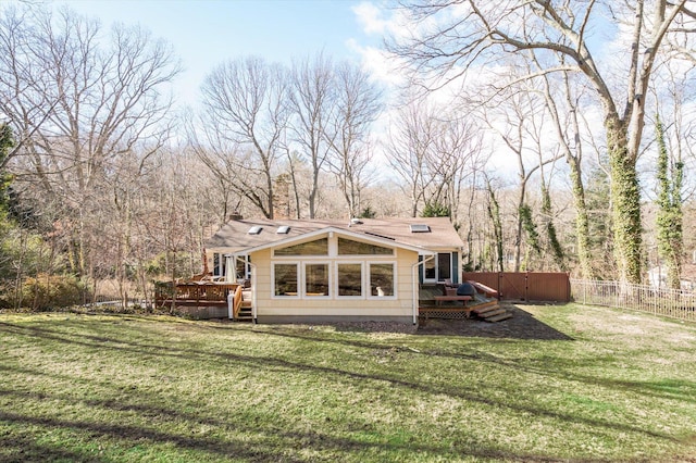 rear view of house with a fenced backyard, a lawn, and a wooden deck