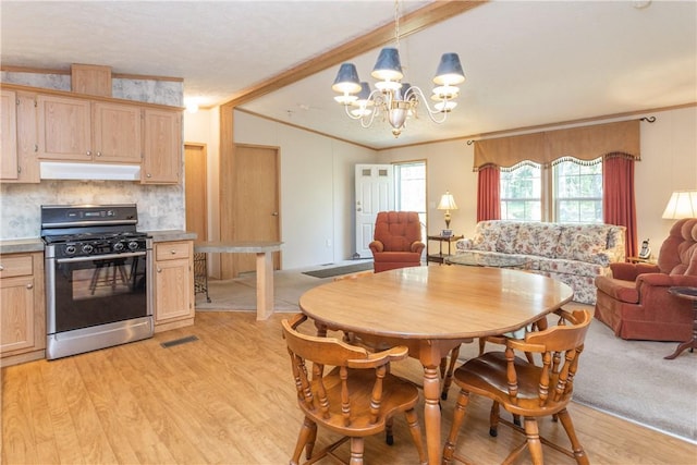 dining space featuring crown molding, an inviting chandelier, and light hardwood / wood-style floors