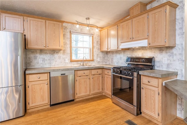 kitchen featuring appliances with stainless steel finishes, sink, light brown cabinets, and light hardwood / wood-style floors