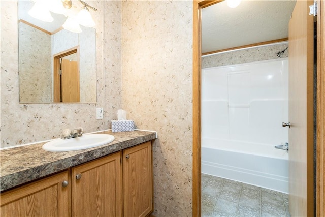 bathroom with vanity, bathing tub / shower combination, and a textured ceiling