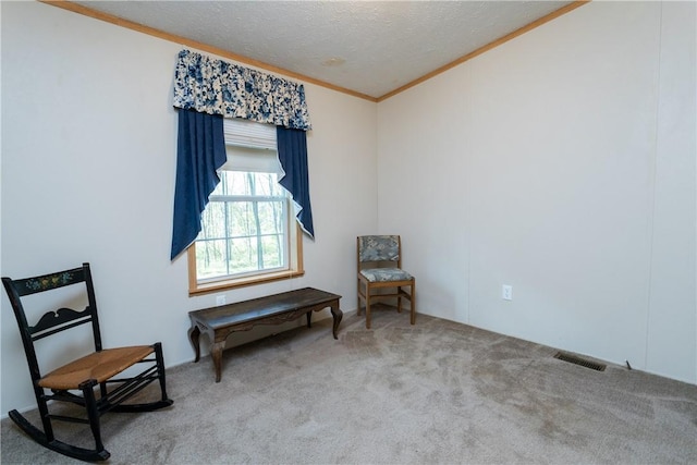 living area with ornamental molding, a textured ceiling, and carpet