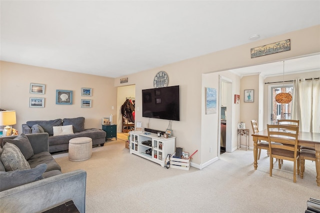 living room with baseboards and light colored carpet