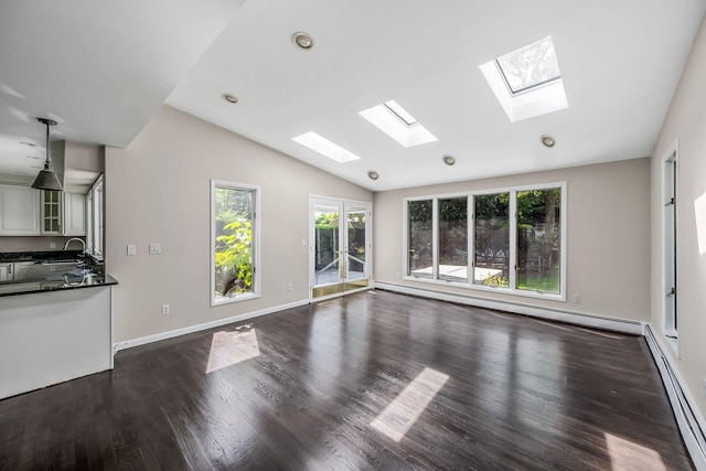 10 Clearbrook Dr, Smithtown, NY 11787 - unfurnished living room featuring a skylight, vaulted ceiling, a sink, dark wood-type flooring, and baseboard heating