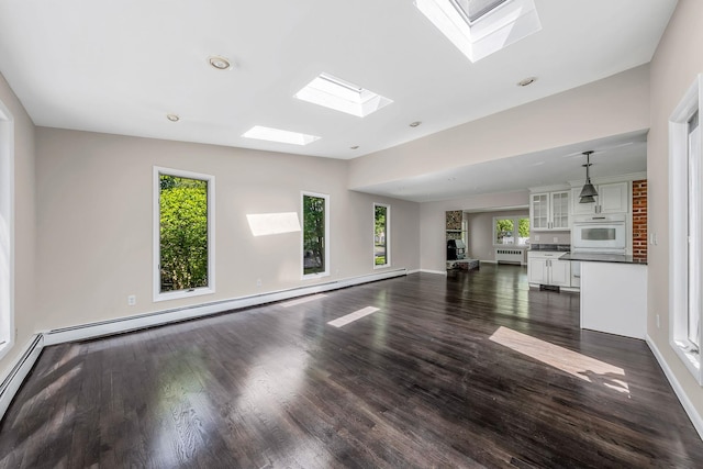 10 Clearbrook Dr, Smithtown, NY 11787 - unfurnished living room featuring a skylight, plenty of natural light, dark wood finished floors, and lofted ceiling
