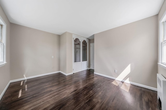 10 Clearbrook Dr, Smithtown, NY 11787 - empty room featuring dark wood-type flooring, radiator heating unit, and baseboards