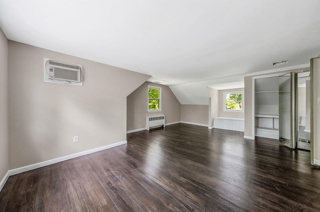 10 Clearbrook Dr, Smithtown, NY 11787 - bonus room featuring radiator, a wall mounted air conditioner, dark wood-type flooring, baseboards, and lofted ceiling