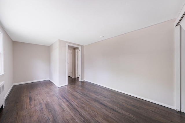 10 Clearbrook Dr, Smithtown, NY 11787 - spare room featuring dark wood-style flooring, baseboards, and radiator heating unit