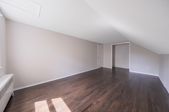 10 Clearbrook Dr, Smithtown, NY 11787 - bonus room with radiator heating unit, dark wood-style flooring, lofted ceiling, and baseboards