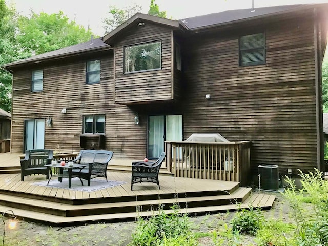 rear view of house with a deck, cooling unit, and outdoor lounge area