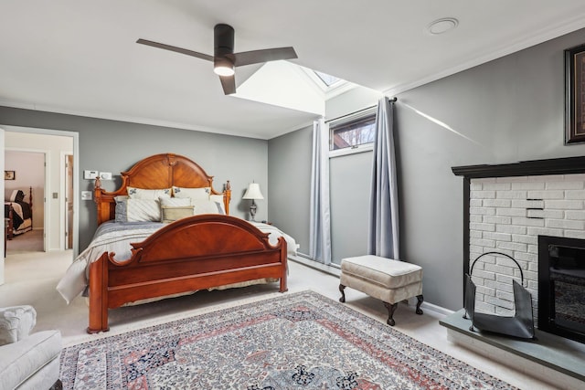 bedroom featuring a fireplace, ornamental molding, a skylight, and light carpet