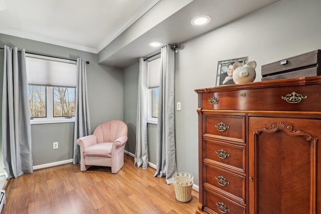 sitting room with light hardwood / wood-style floors, crown molding, and a baseboard heating unit