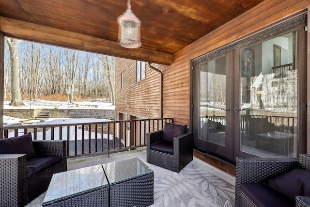 snow covered deck with french doors