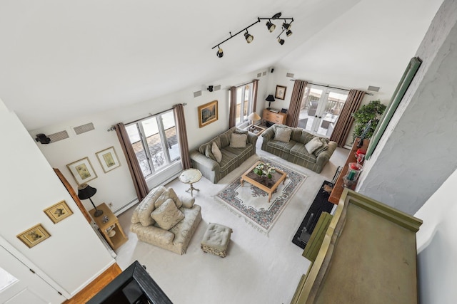 living room featuring vaulted ceiling, rail lighting, and baseboard heating