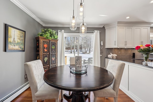 dining area with baseboard heating, dark hardwood / wood-style flooring, and crown molding