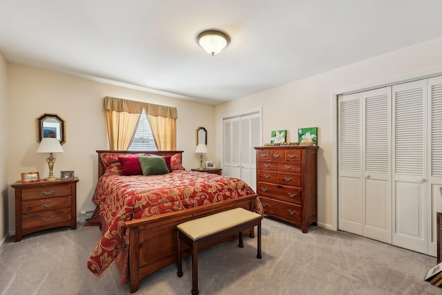 carpeted bedroom with two closets and a baseboard heating unit