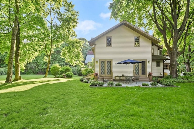 back of property featuring french doors, a patio, and a lawn